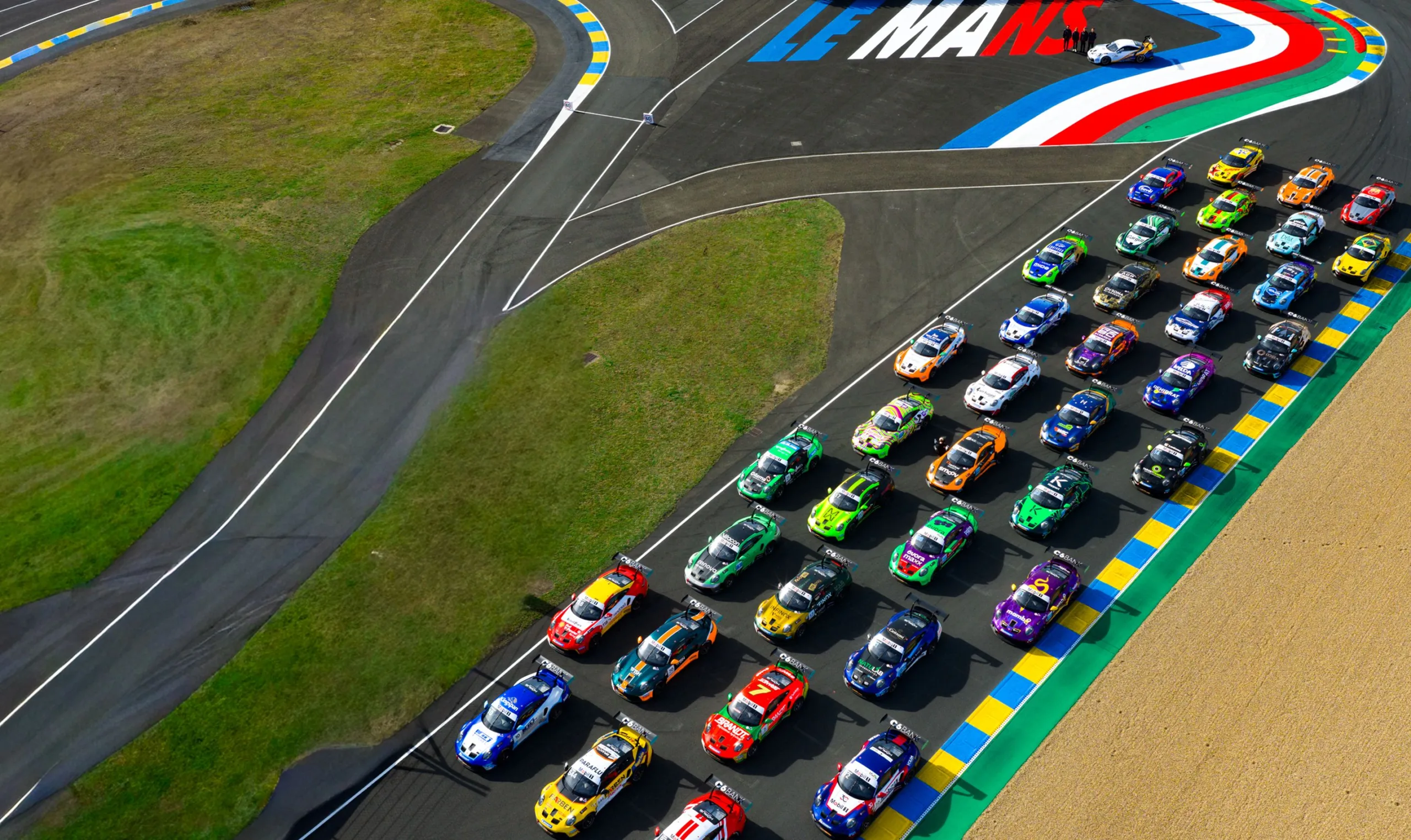 Vista aérea do grid de carros da Porsche Cup alinhados no circuito de Le Mans
